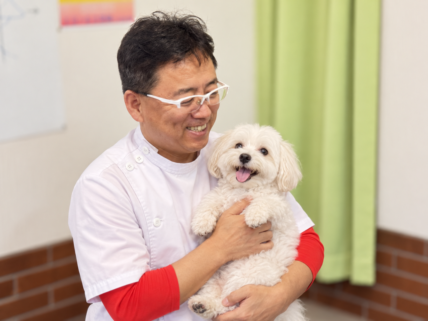 白い犬を抱く院長 李光林