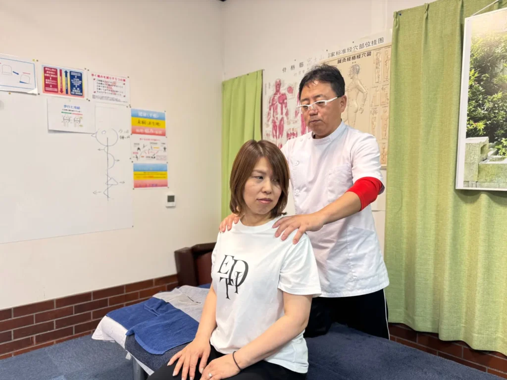 肩に手を添えて身体の状態を確認する様子