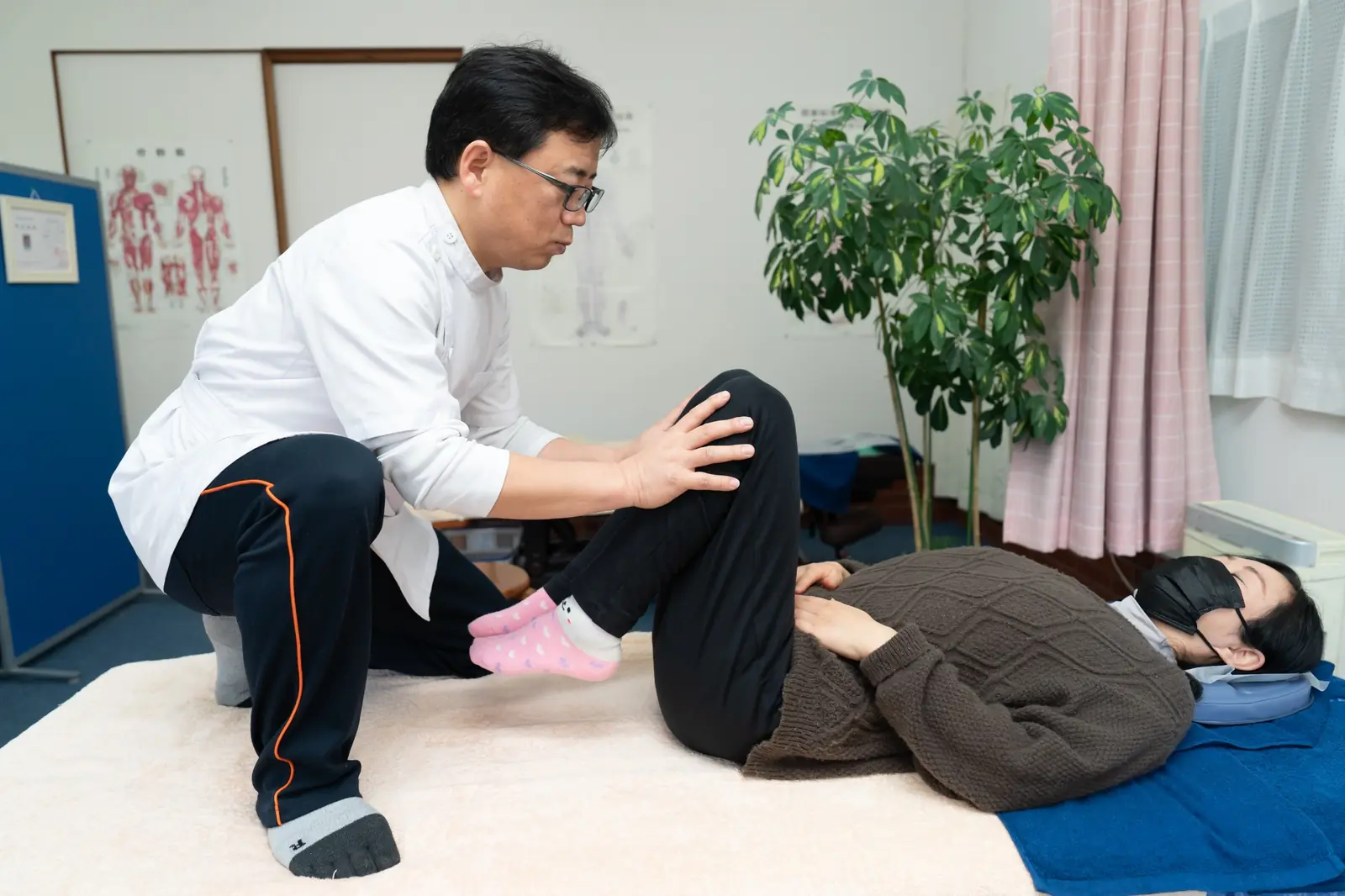 院長が患者さまの膝と股関節を確認する施術の様子