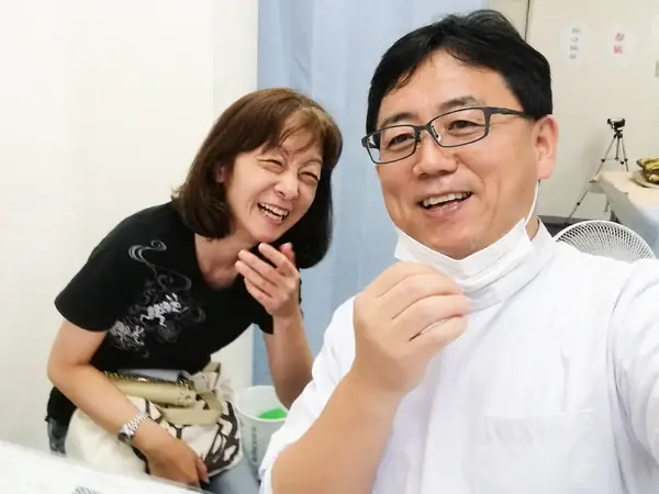 院長 李光林と笑顔で並ぶ女性の写真